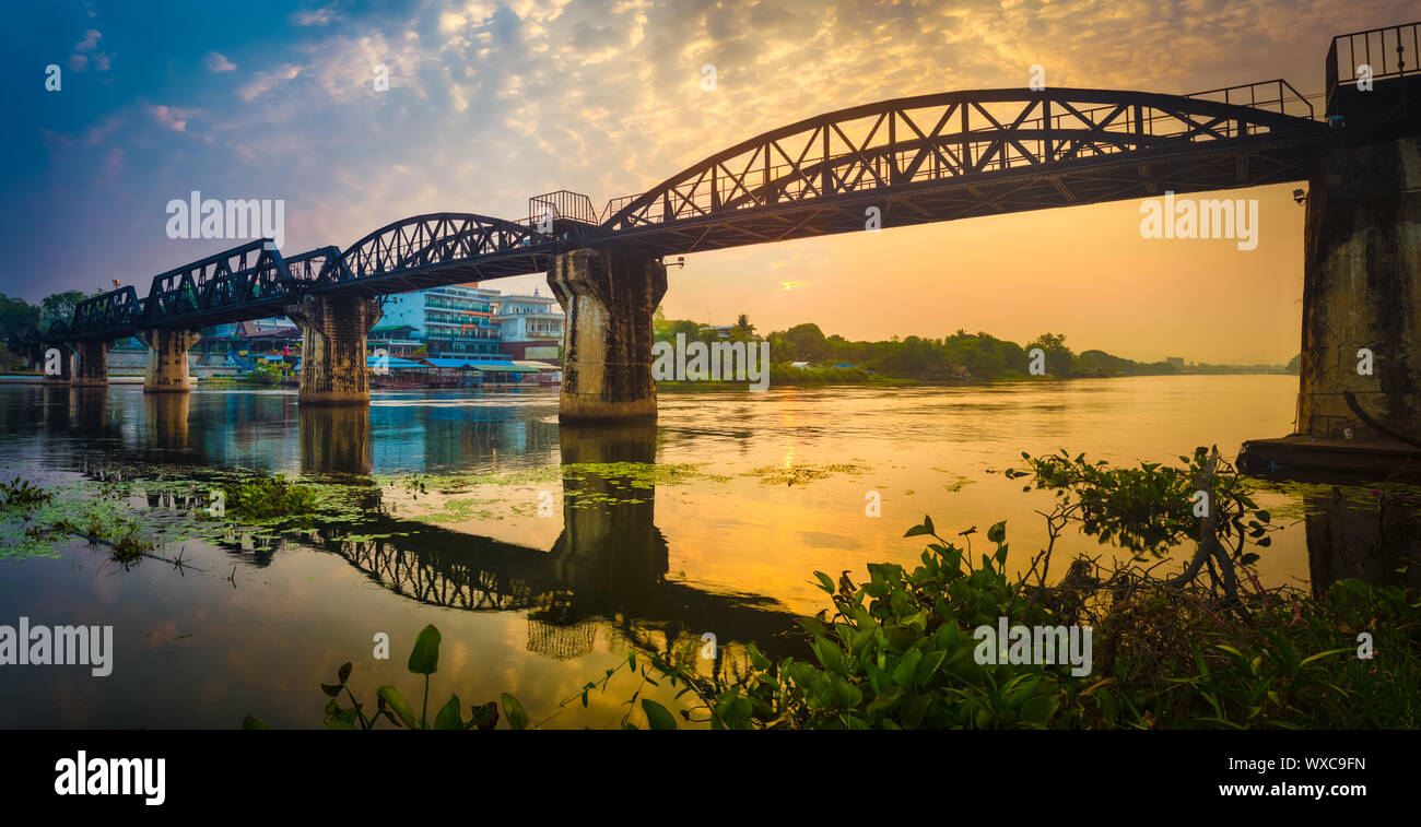 Il ponte sul fiume Kwai a sunrise. Stazione ferroviaria di Kanchanaburi, Thailandia. Panorama Foto Stock