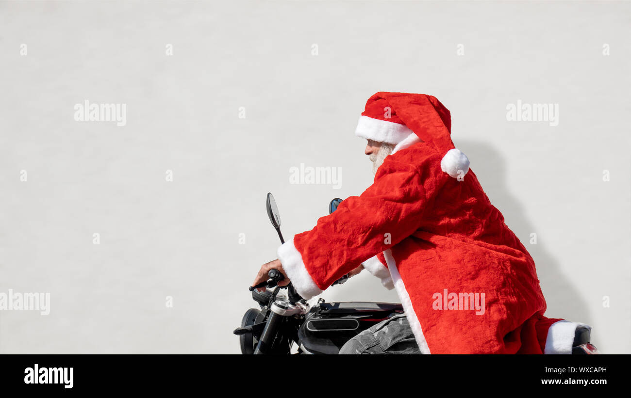 Un uomo su una moto in una tipica Santa Claus costume Foto Stock