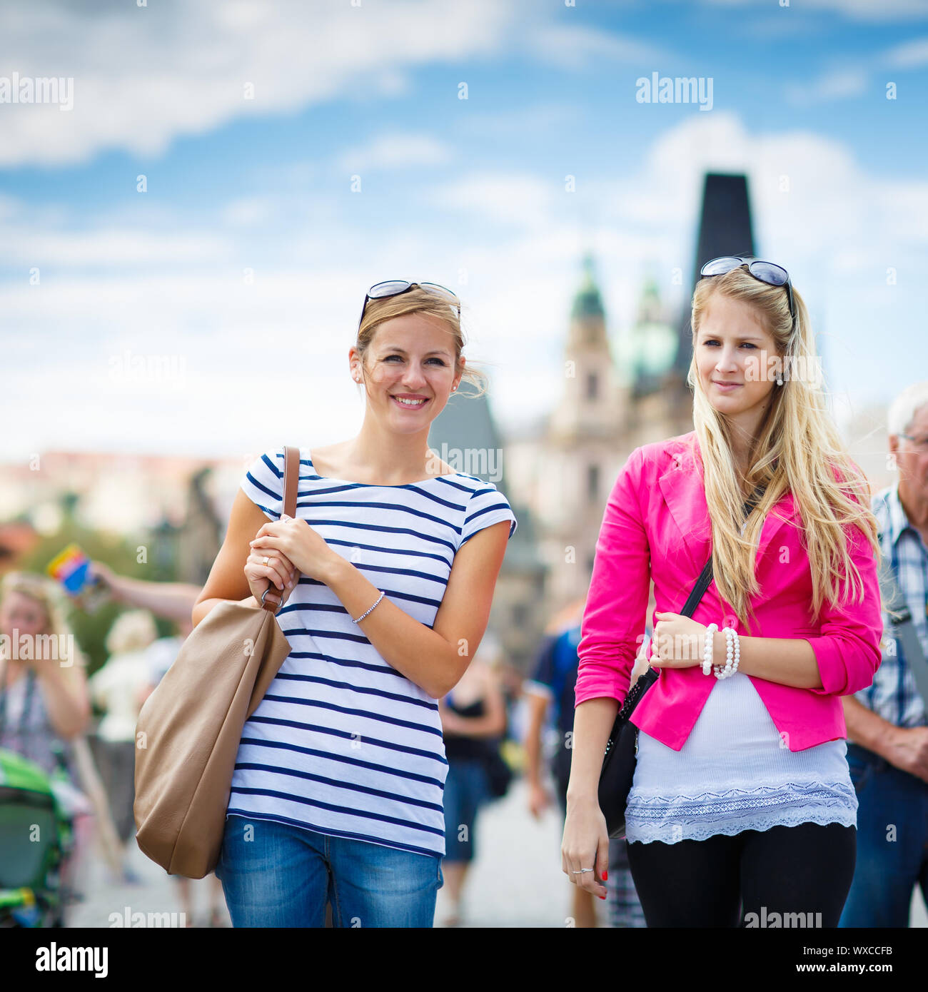 Due turisti femmina camminando lungo il ponte Carlo durante la visita a Praga, la storica capitale della Repubblica ceca (toni di colore immagine; sha Foto Stock