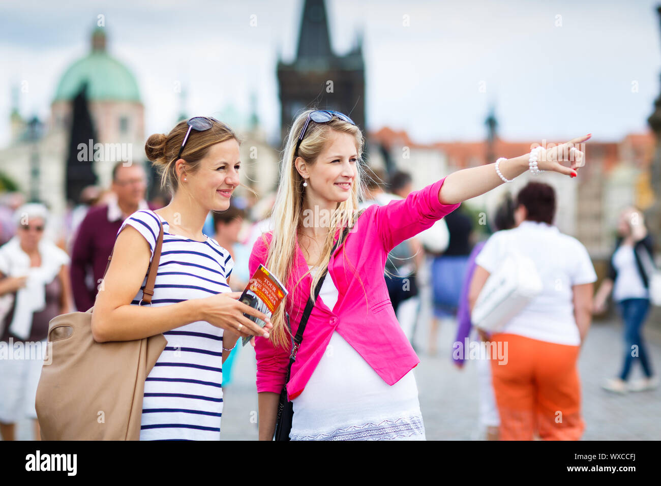 Due turisti femmina camminando lungo il ponte Carlo durante la visita a Praga, la storica capitale della Repubblica ceca (toni di colore immagine; sha Foto Stock