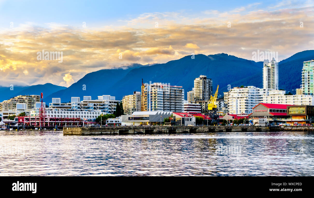 Tramonto su edifici alti e Lonsdale Quay Market in North Vancouver. Vista dal porto di una nave da crociera nel porto di Vancouver in BC, Canada Foto Stock