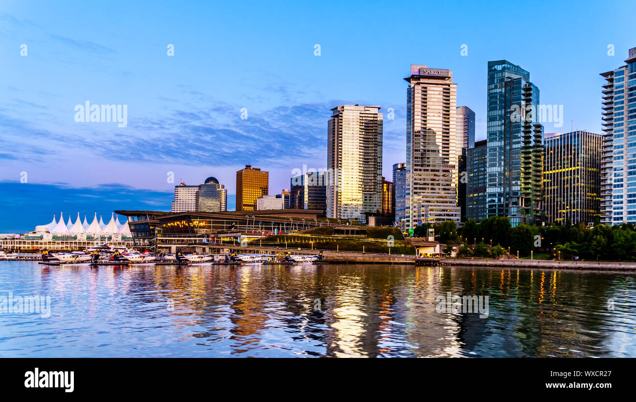 Tramonto sul alti edifici che formano il centro e il porto di carbone skyline. Vista dal porto di una nave da crociera nel porto di Vancouver in BC Foto Stock