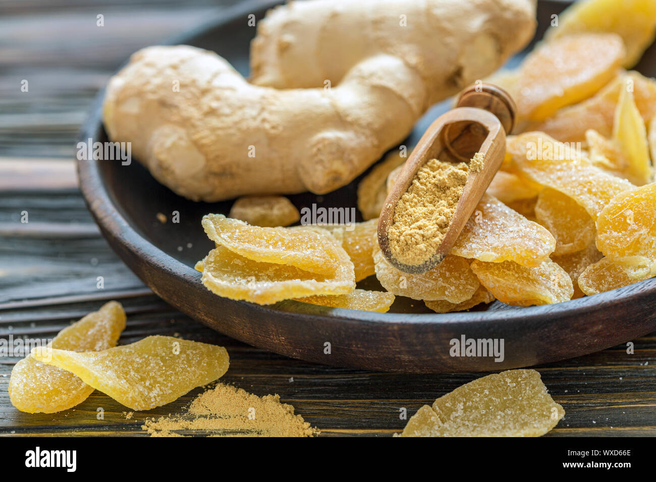 Radice di Zenzero e zenzero candito su una lastra di legno. Foto Stock