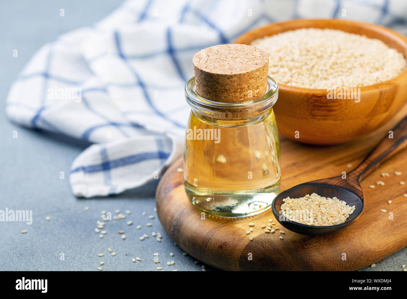 Organici di olio di sesamo e i semi di sesamo in un cucchiaio di legno. Foto Stock