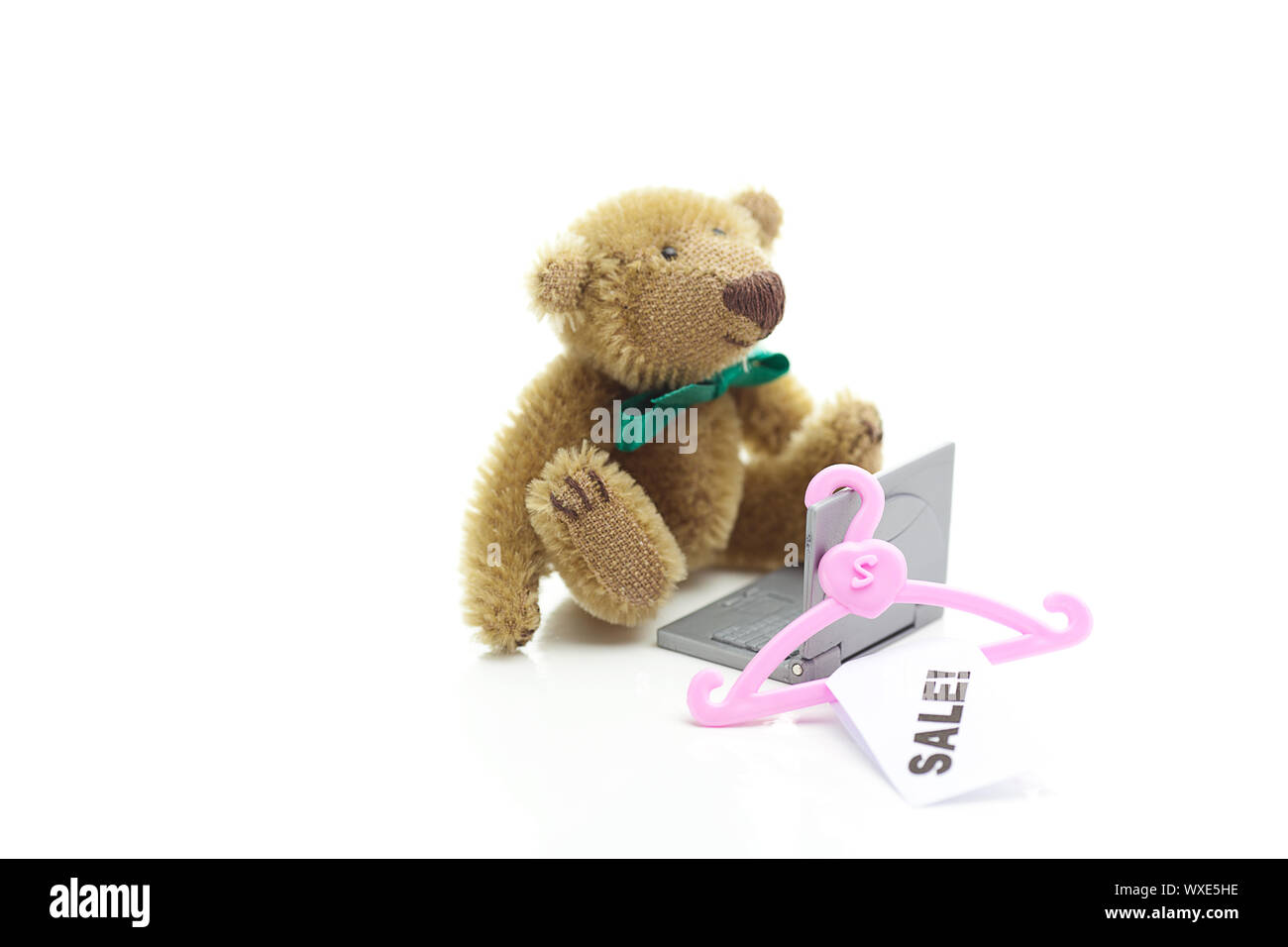 Orsacchiotto di peluche,appendiabiti con un cartellino del prezzo di vendita e portatile in miniatura isolato su bianco Foto Stock