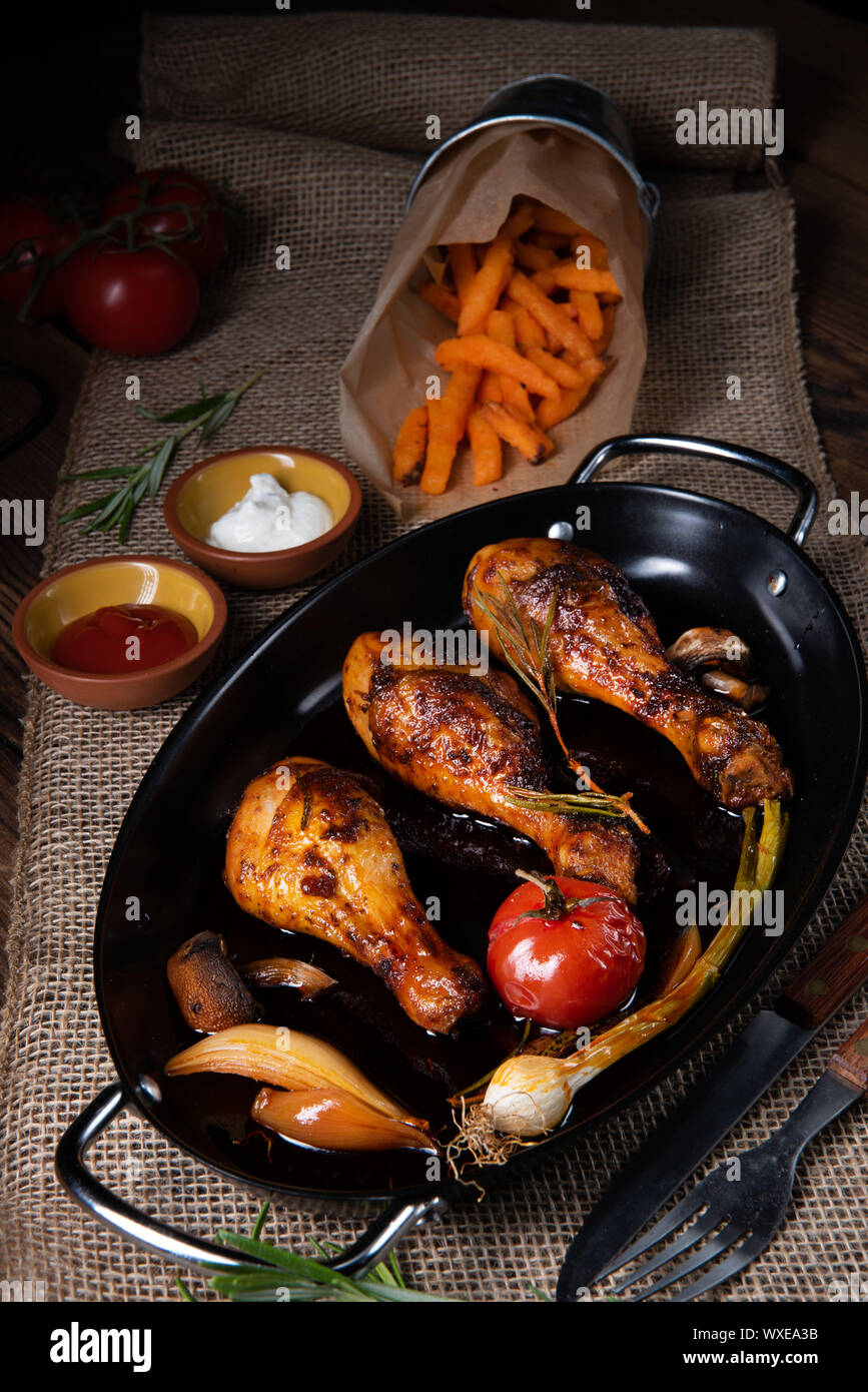 Grigliate le cosce di pollo nel barbecue marinata con patate dolci Foto Stock