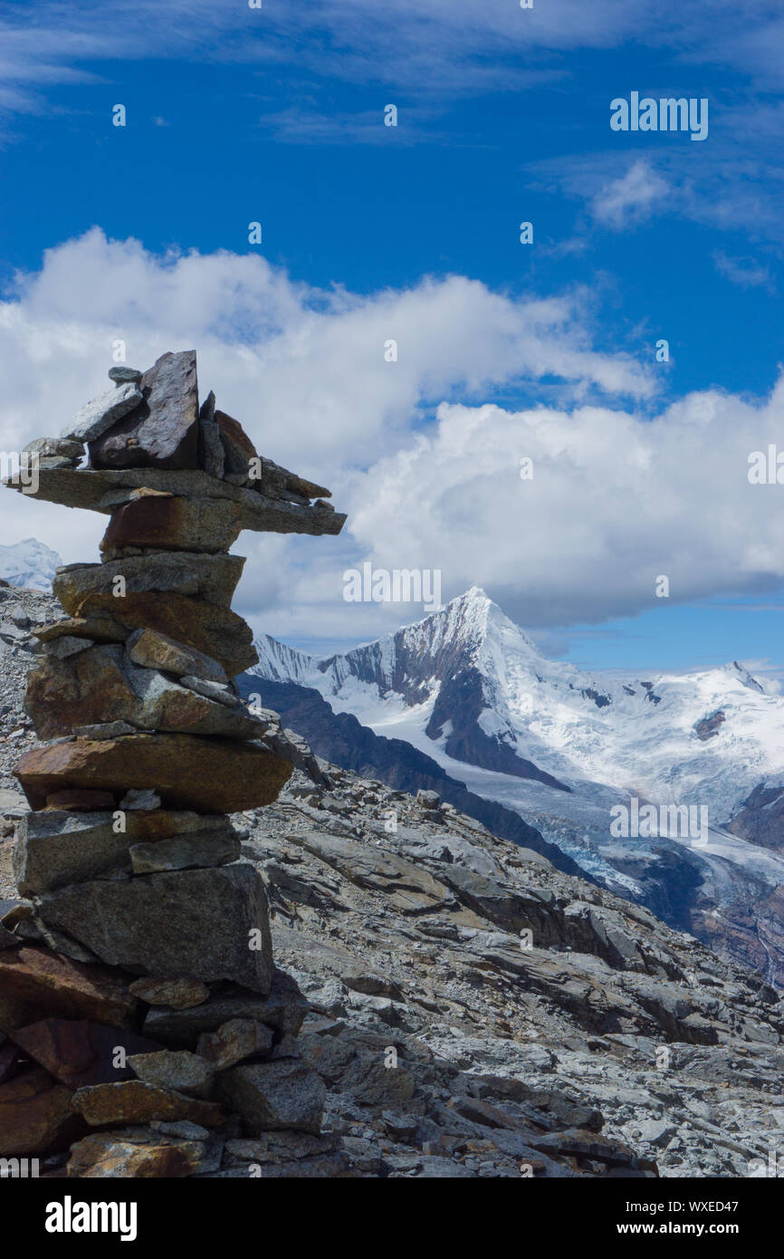 Il pittoresco paesaggio di montagna nelle Ande del Perù con una pietra cairn in primo piano Foto Stock