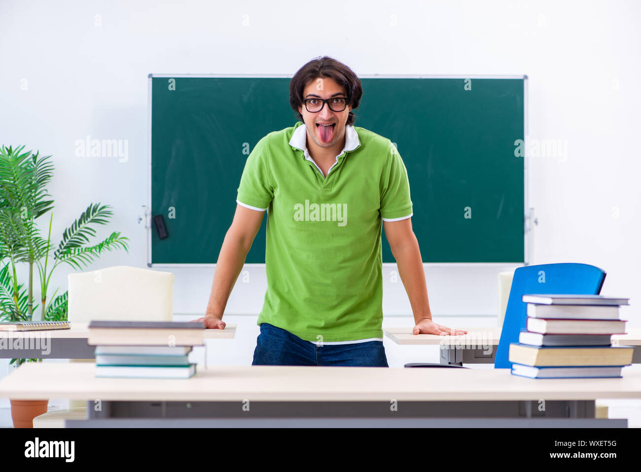 Giovane studente facendo esercizi fisici in aula Foto Stock