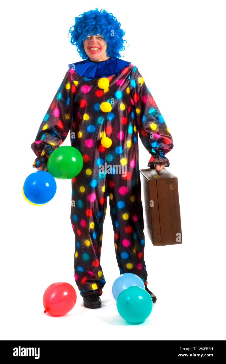 Il clown è in viaggio con la valigia e palloncini Foto Stock