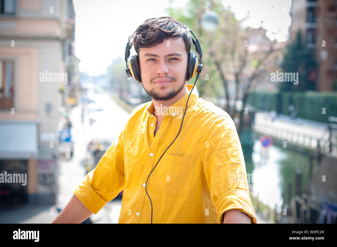 Hipster giovane uomo ascoltare musica sul balcone Foto Stock