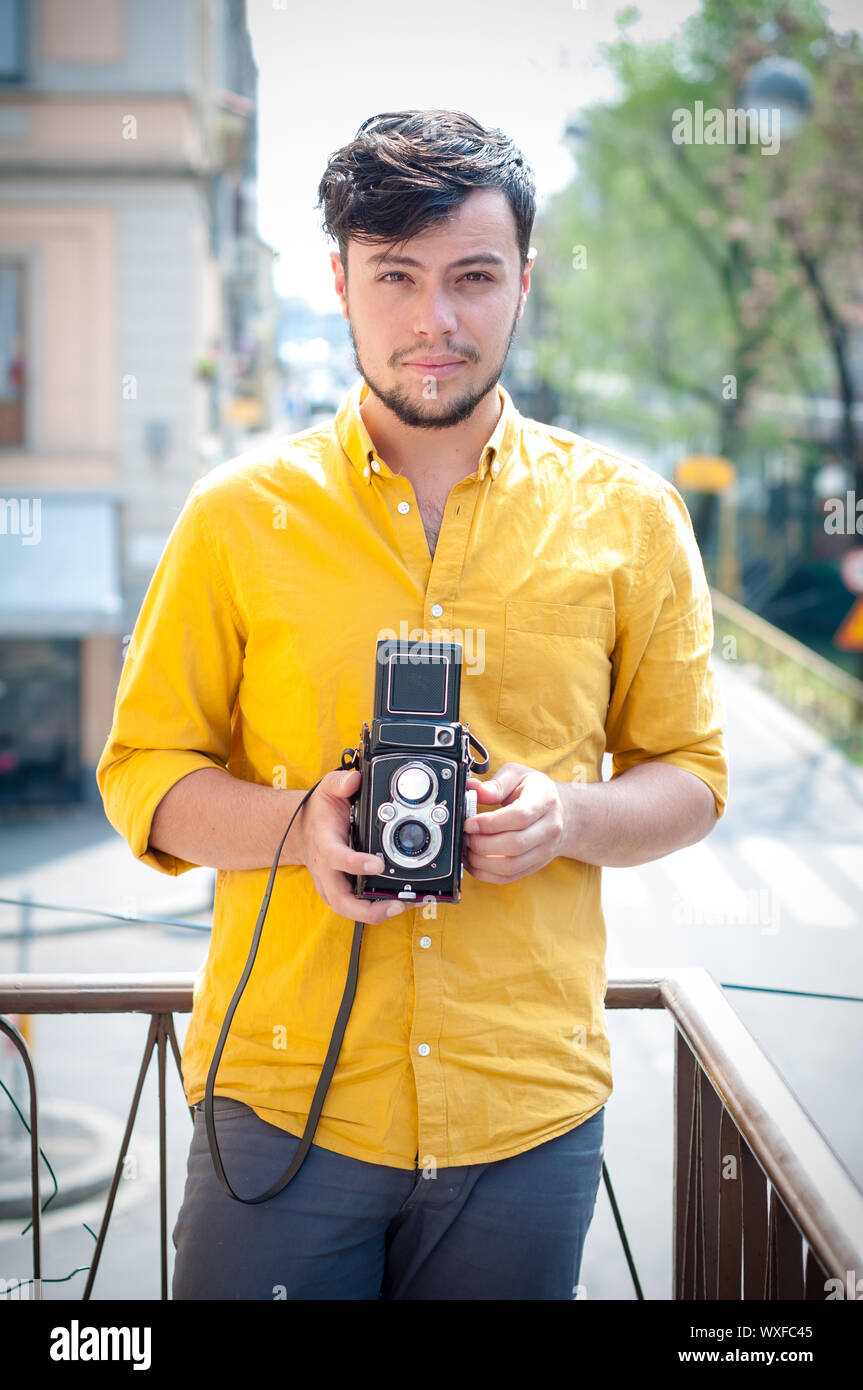 Hipster giovane uomo con la vecchia macchina fotografica sul balcone Foto Stock