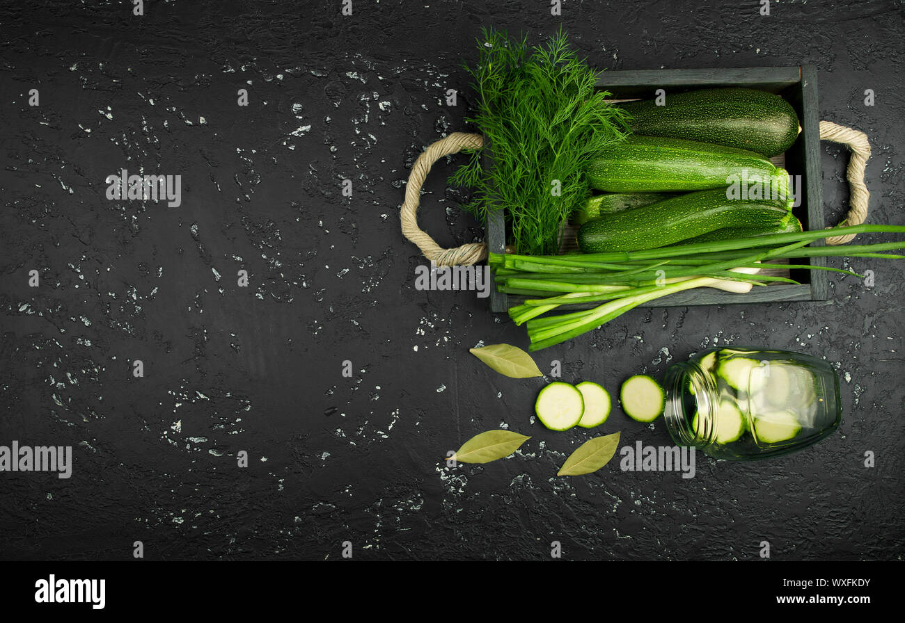Fresco verde di zucchina al buio su un tavolo. La vista dall'alto. Copia dello spazio. Foto Stock