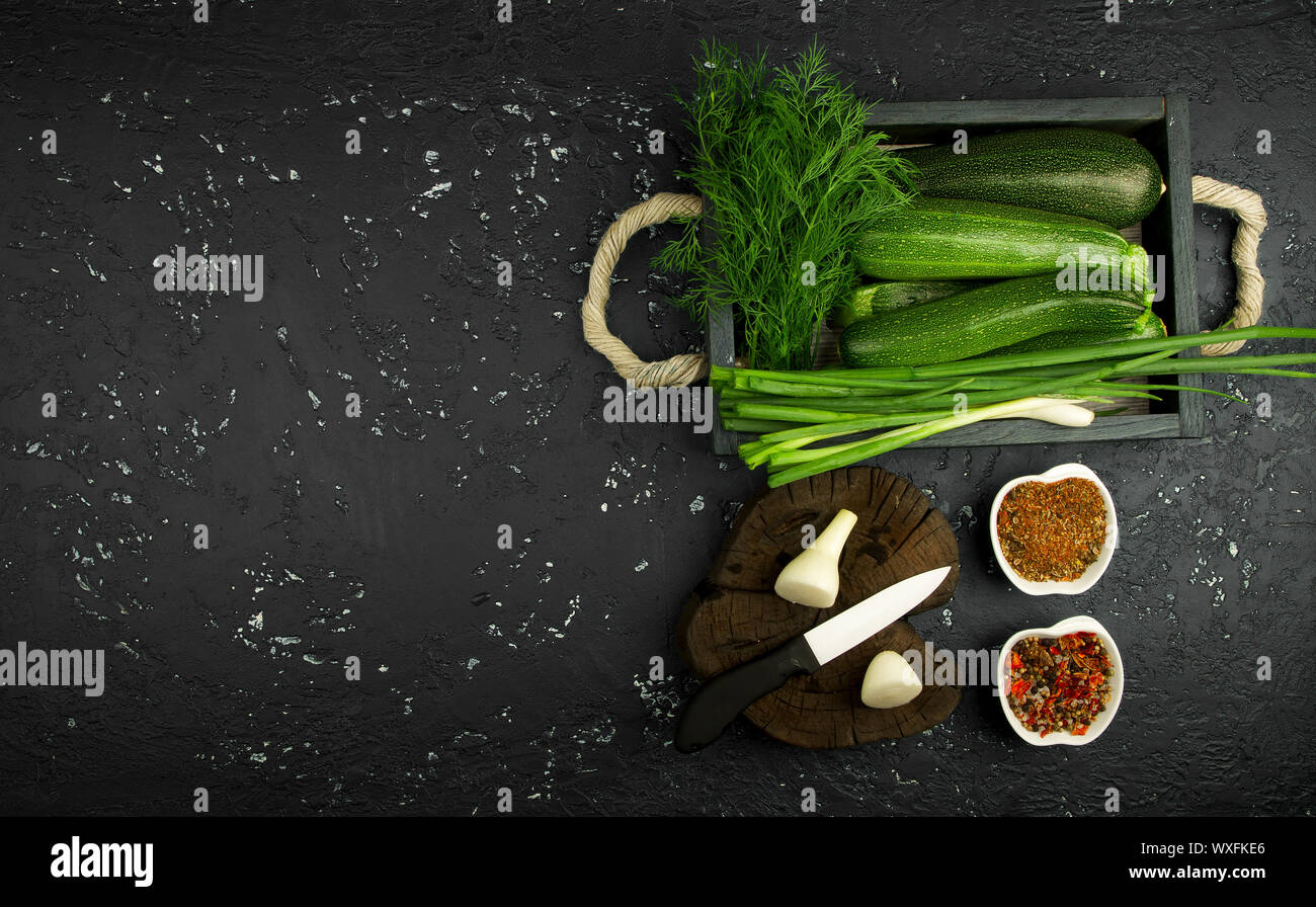 Fresco verde di zucchina al buio su un tavolo. La vista dall'alto. Copia dello spazio. Foto Stock