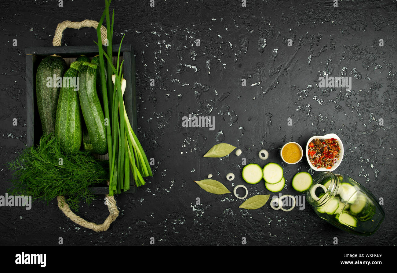 Fresco verde di zucchina al buio su un tavolo. La vista dall'alto. Copia dello spazio. Foto Stock