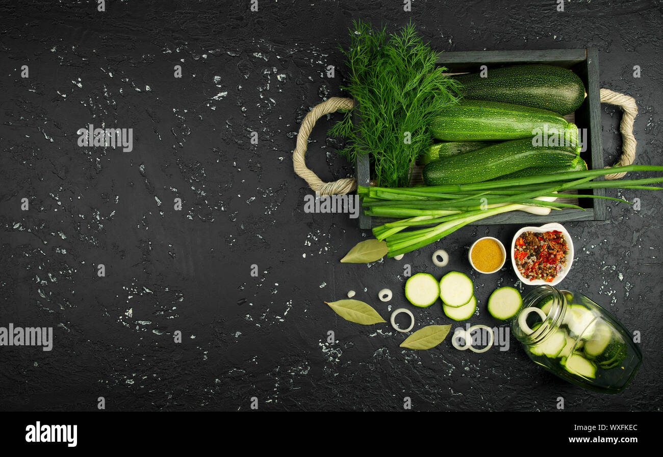 Fresco verde di zucchina al buio su un tavolo. La vista dall'alto. Copia dello spazio. Foto Stock