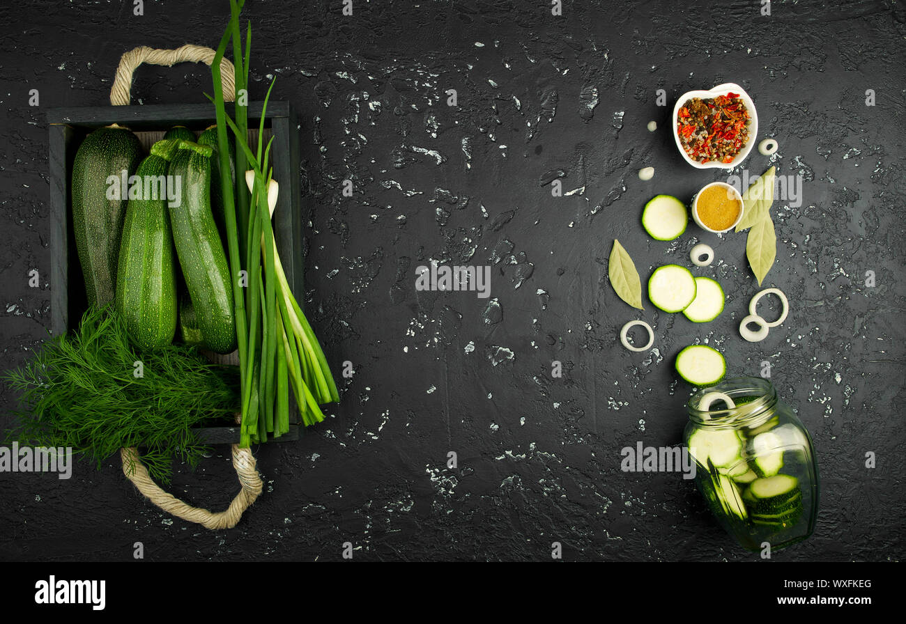Fresco verde di zucchina al buio su un tavolo. La vista dall'alto. Copia dello spazio. Foto Stock