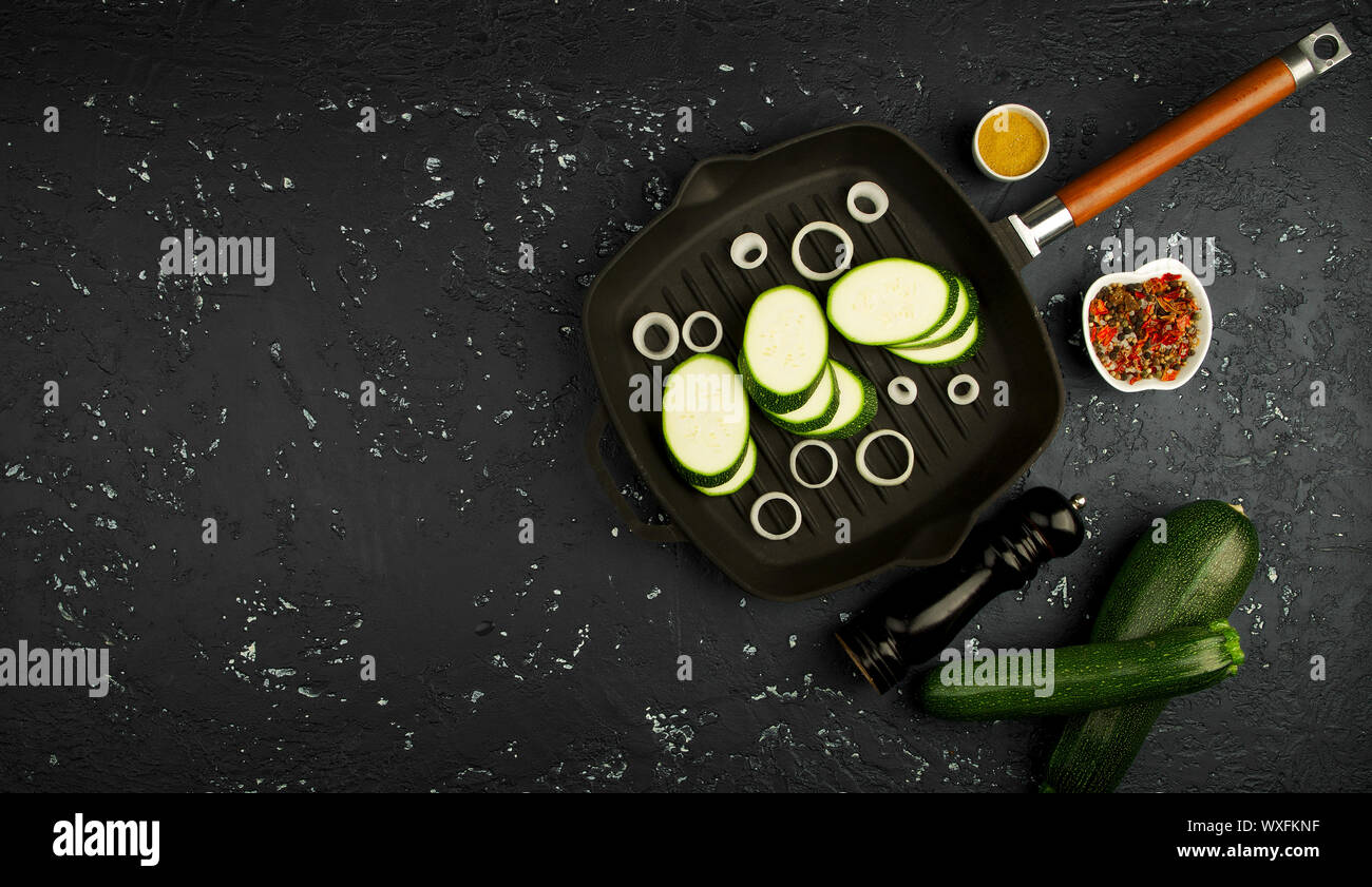 Fresco verde di zucchina al buio su un tavolo. La vista dall'alto. Copia dello spazio. Foto Stock