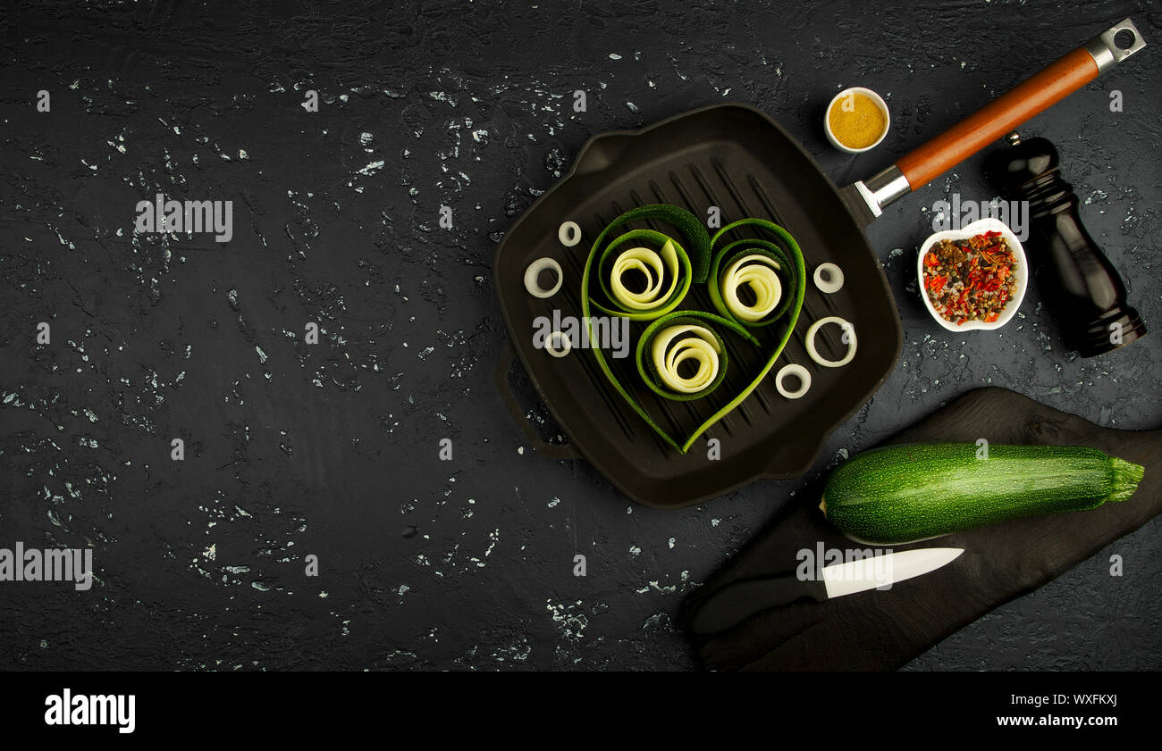 Fresco verde di zucchina al buio su un tavolo. La vista dall'alto. Copia dello spazio. Foto Stock