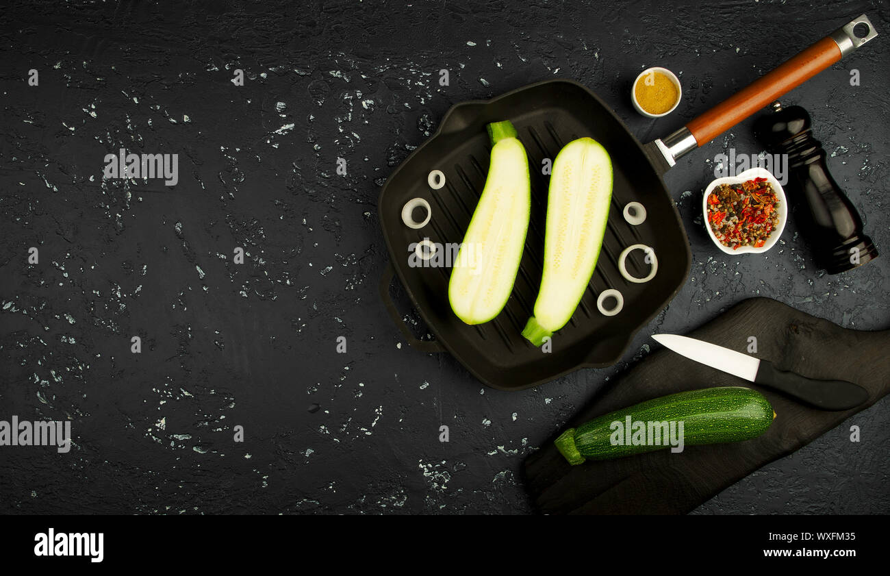 Fresco verde di zucchina al buio su un tavolo. La vista dall'alto. Copia dello spazio. Foto Stock