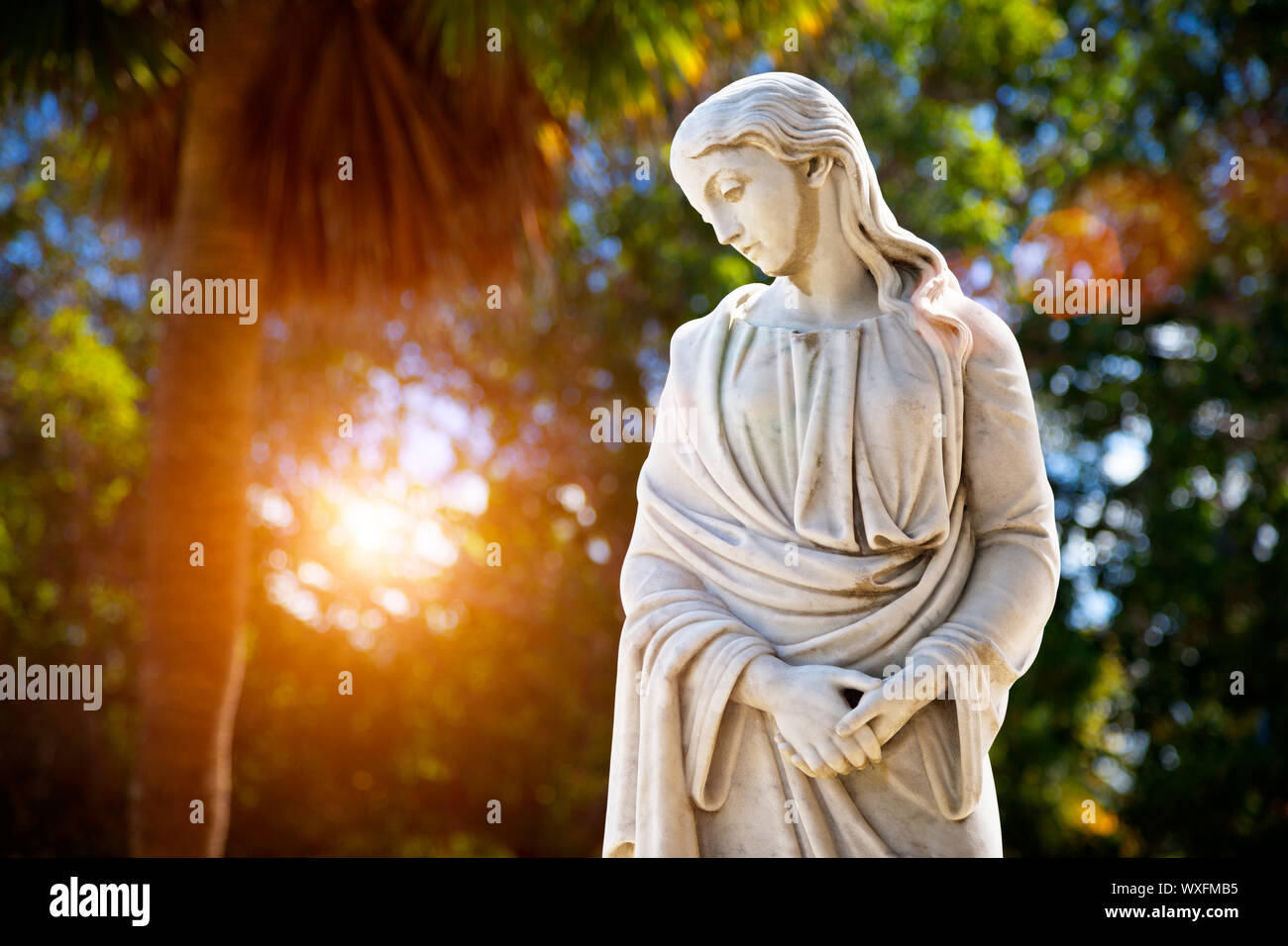 Una giovane donna con le mani giunte guardando verso il basso. Scultura nel parco Foto Stock