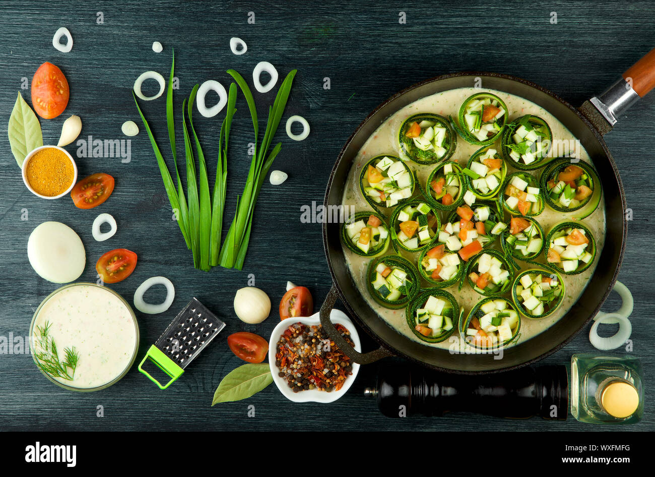 Zucchine in background. Giovani fritto le zucchine tagliate a fette in una padella su uno sfondo scuro. La vista dall'alto. Spazio di copia Foto Stock