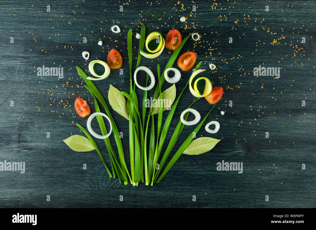 Arco sullo sfondo. Arco verde delle cipolle, cipolle bianche e pomodoro su un forte piano di legno. Concetto di immagine vegetale. V Foto Stock
