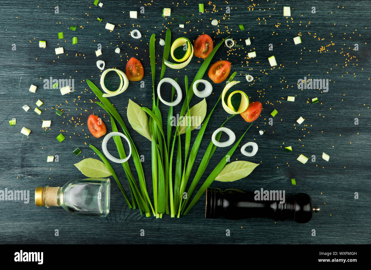 Arco sullo sfondo. Arco verde delle cipolle, cipolle bianche e pomodoro su un forte piano di legno. Concetto di immagine vegetale. V Foto Stock