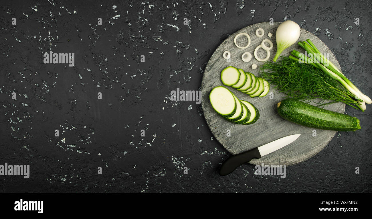 Fresco verde di zucchina al buio su un tavolo. La vista dall'alto. Copia dello spazio. Foto Stock