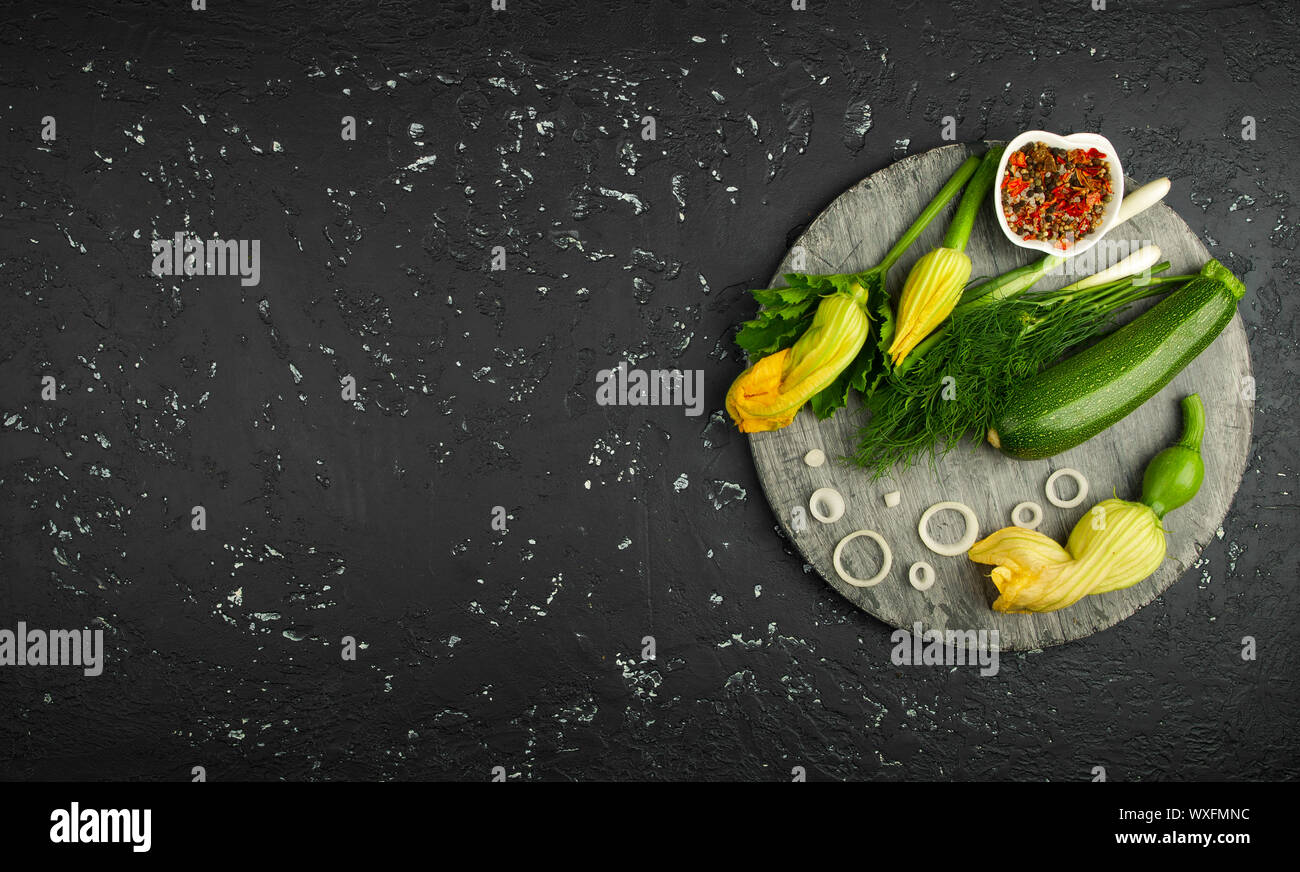 Fresco verde di zucchina al buio su un tavolo. La vista dall'alto. Copia dello spazio. Foto Stock