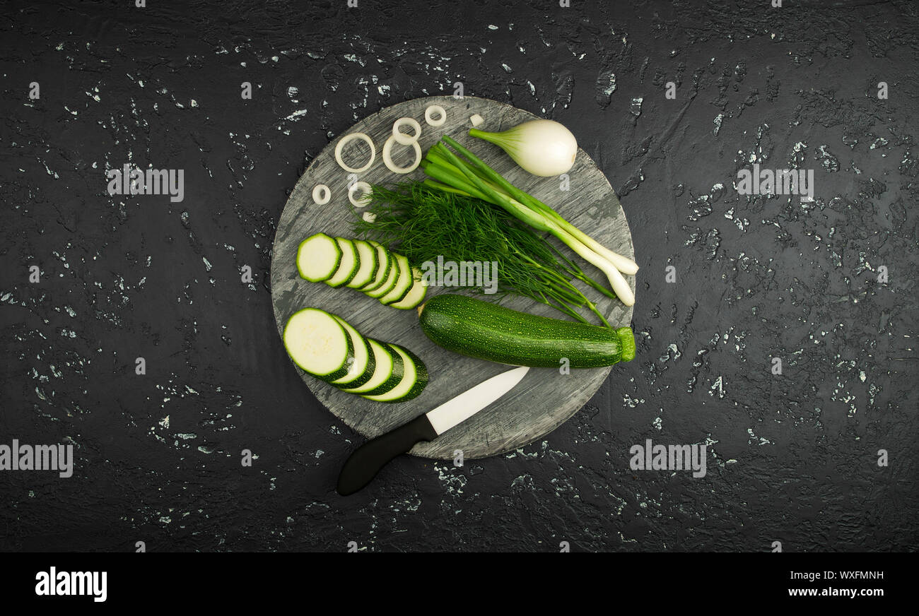 Fresco verde di zucchina al buio su un tavolo. La vista dall'alto. Copia dello spazio. Foto Stock
