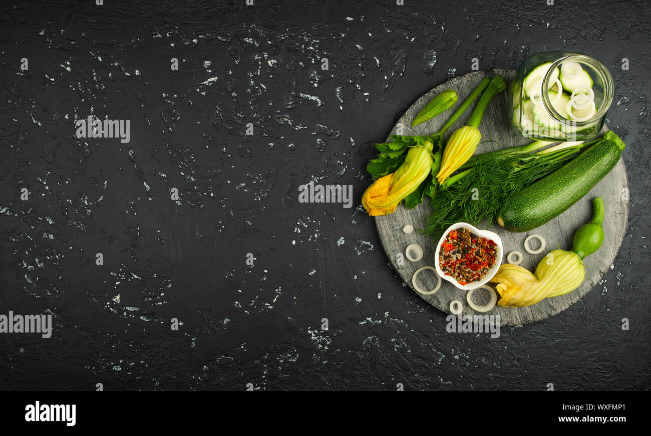 Fresco verde di zucchina al buio su un tavolo. La vista dall'alto. Copia dello spazio. Foto Stock