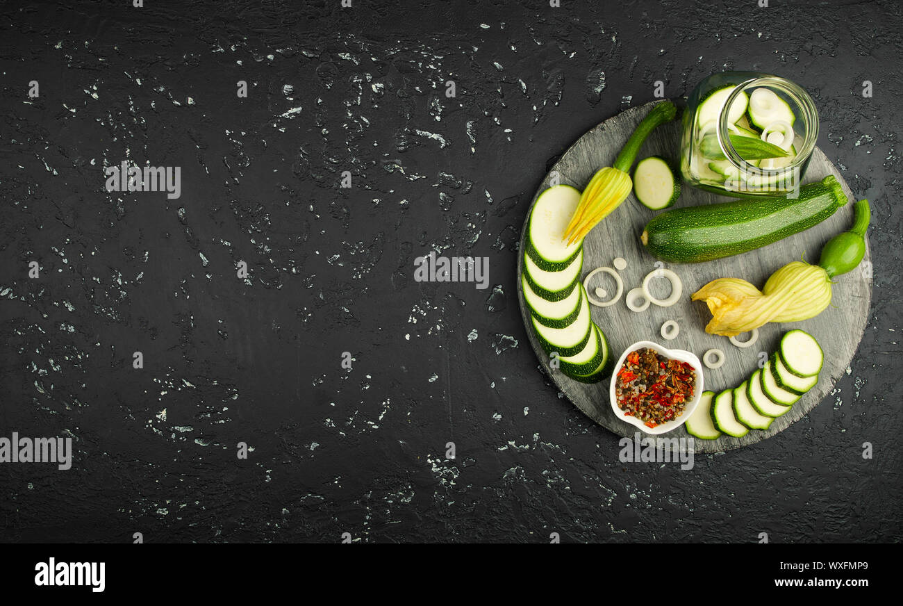 Fresco verde di zucchina al buio su un tavolo. La vista dall'alto. Copia dello spazio. Foto Stock