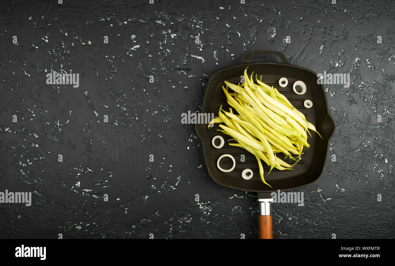 Stringa di freschi fagioli in scatola al buio su un tavolo. Vista da sopra. Spazio di copia Foto Stock