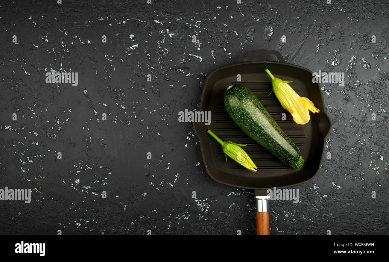 Fresco verde di zucchina al buio su un tavolo. La vista dall'alto. Copia dello spazio. Foto Stock
