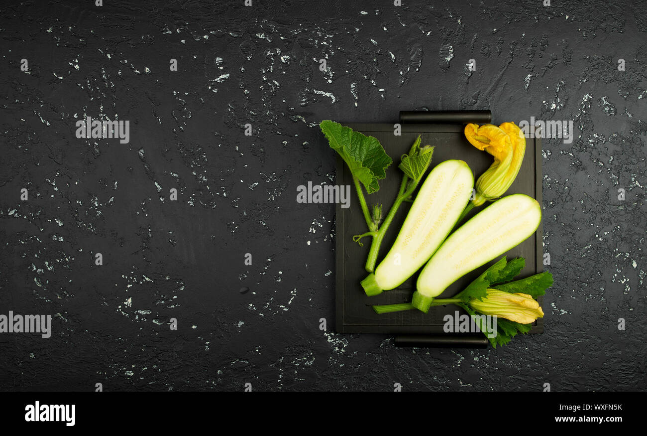Fresco verde di zucchina al buio su un tavolo. La vista dall'alto. Copia dello spazio. Foto Stock