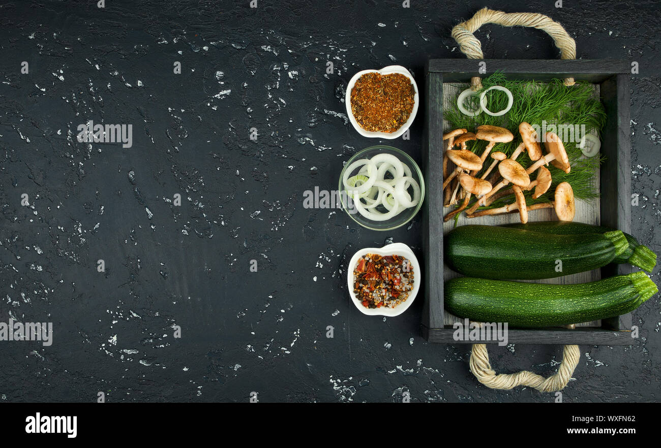 Fresco verde di zucchina al buio su un tavolo. La vista dall'alto. Copia dello spazio. Foto Stock