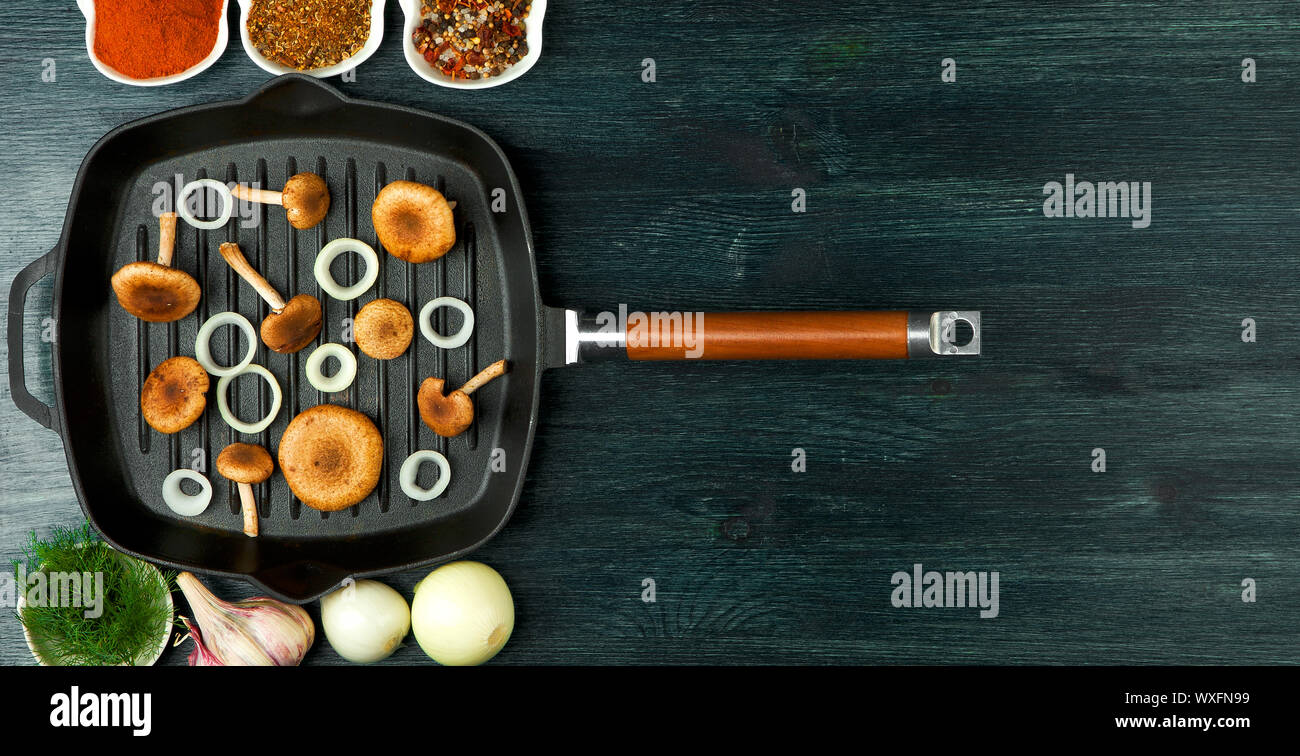 I funghi freschi con le spezie e le erbe sul bordo nero. Vista da sopra. Copia dello spazio. Foto Stock