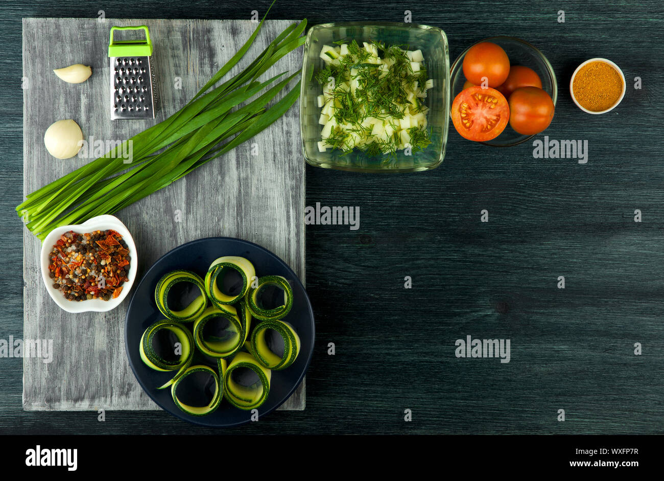 Zucchine in background. Giovani fritto le zucchine tagliate a fette in una padella su uno sfondo scuro. La vista dall'alto. Spazio di copia Foto Stock