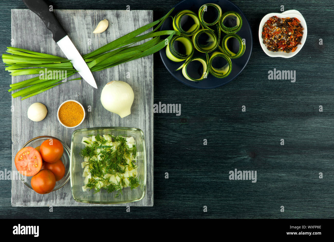 Zucchine in background. Giovani fritto le zucchine tagliate a fette in una padella su uno sfondo scuro. La vista dall'alto. Spazio di copia Foto Stock