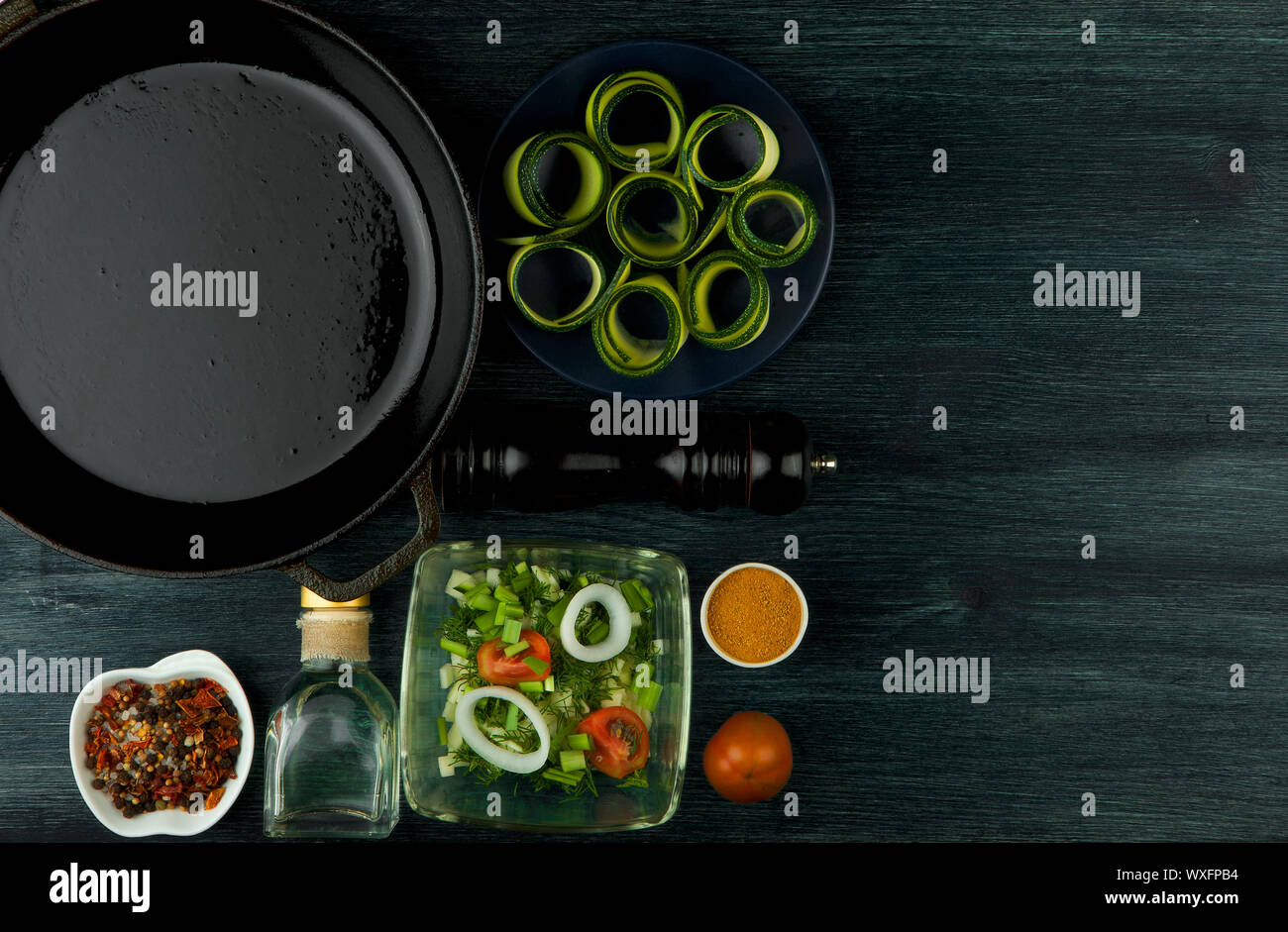 Zucchine in background. Giovani fritto le zucchine tagliate a fette in una padella su uno sfondo scuro. La vista dall'alto. Spazio di copia Foto Stock