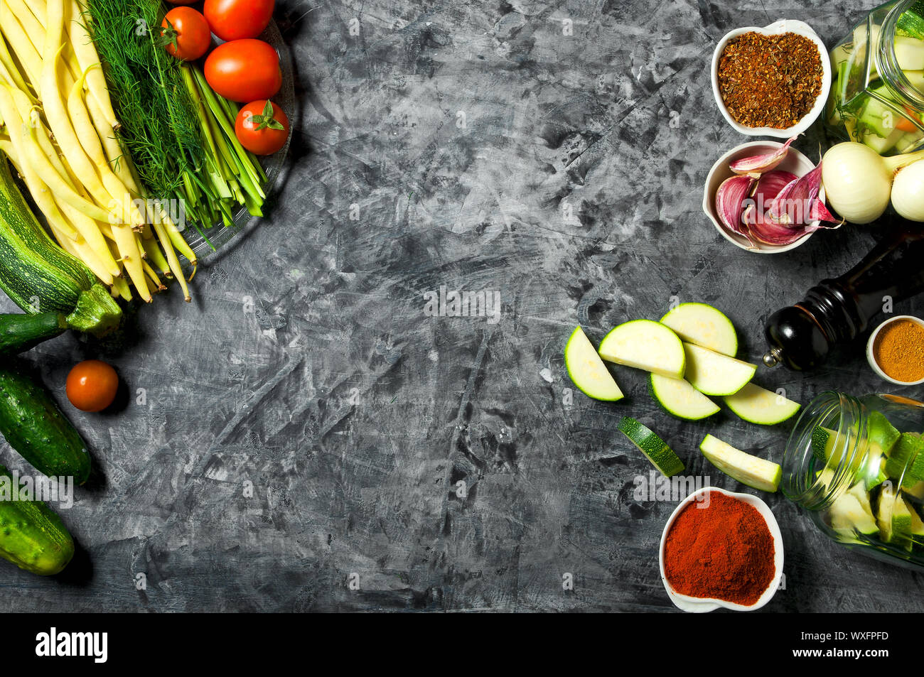 Verdure sullo sfondo. Ortaggi freschi (cetrioli, pomodori, cipolle, aglio, aneto, fagioli verdi) su sfondo grigio. A Foto Stock