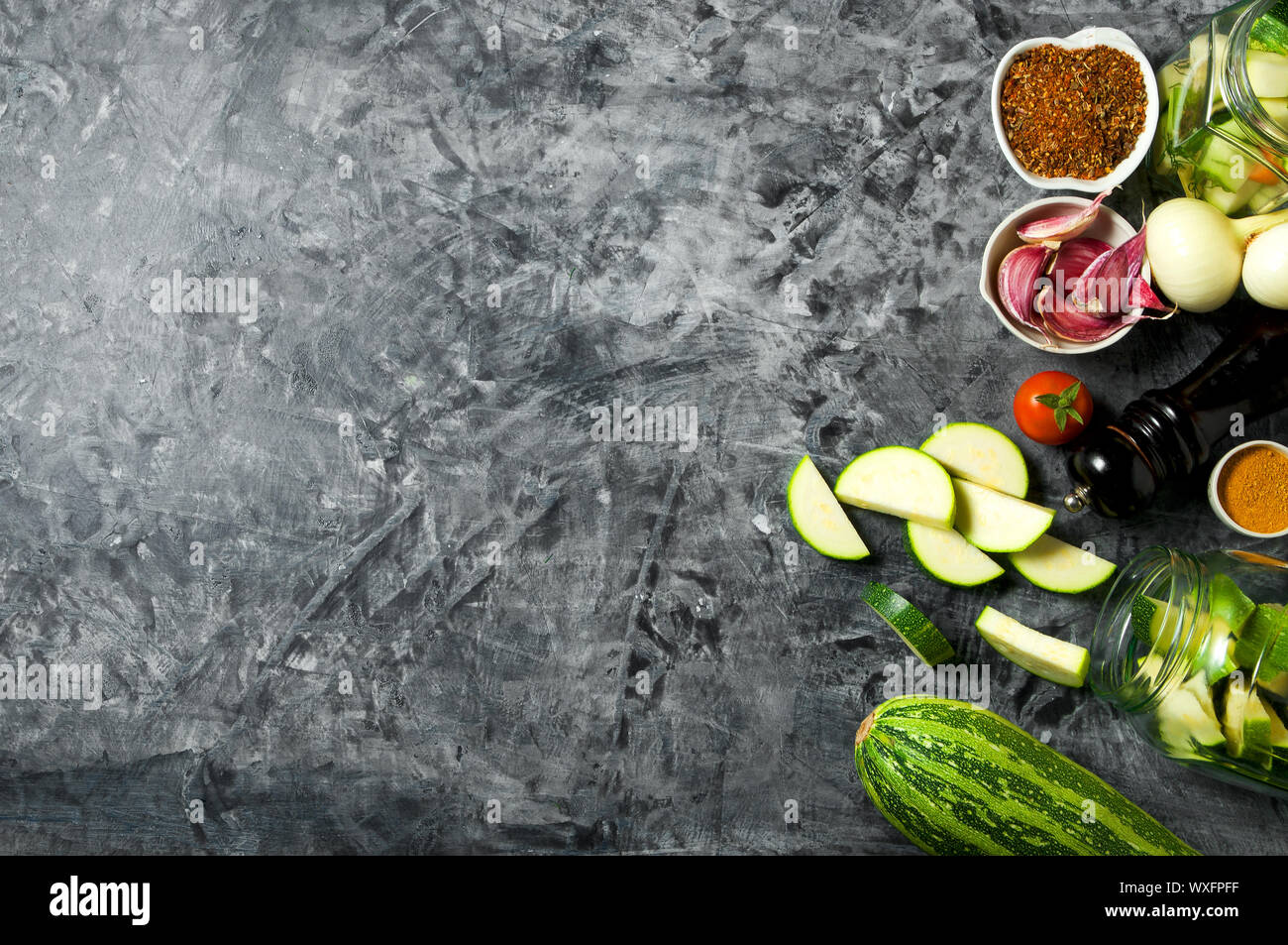 Verdure sullo sfondo. Ortaggi freschi (cetrioli, pomodori, cipolle, aglio, aneto, fagioli verdi) su sfondo grigio. A Foto Stock