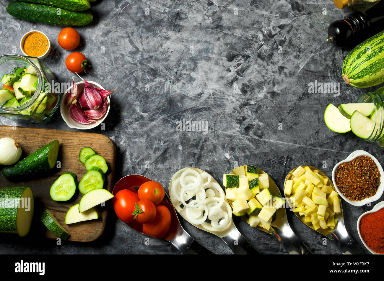 Verdure sullo sfondo. Ortaggi freschi (cetrioli, pomodori, cipolle, aglio, aneto, fagioli verdi) su sfondo grigio. A Foto Stock