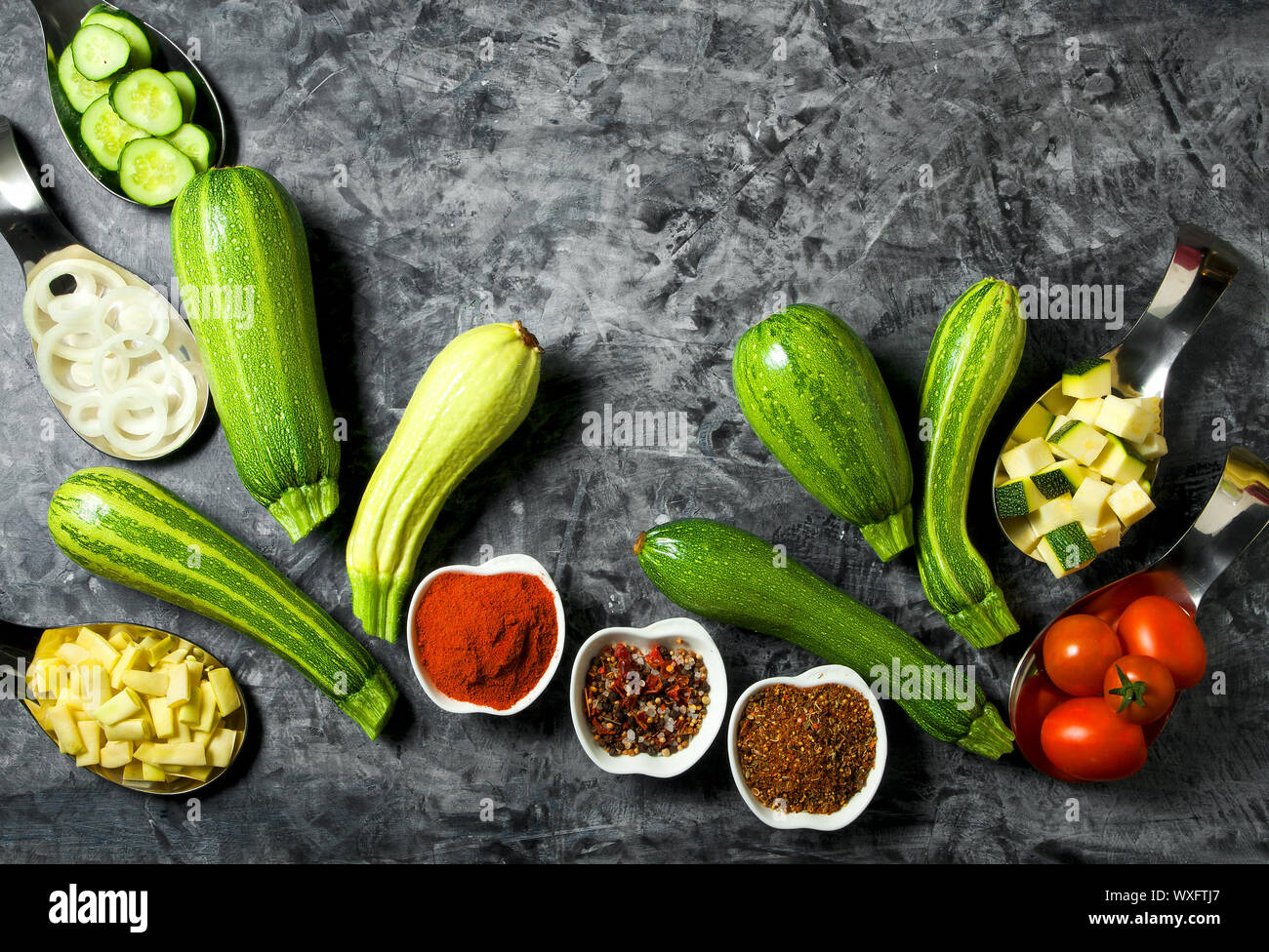 Verdure sullo sfondo. Ortaggi freschi (cetrioli, pomodori, cipolle, aglio, aneto, fagioli verdi) su sfondo grigio. A Foto Stock