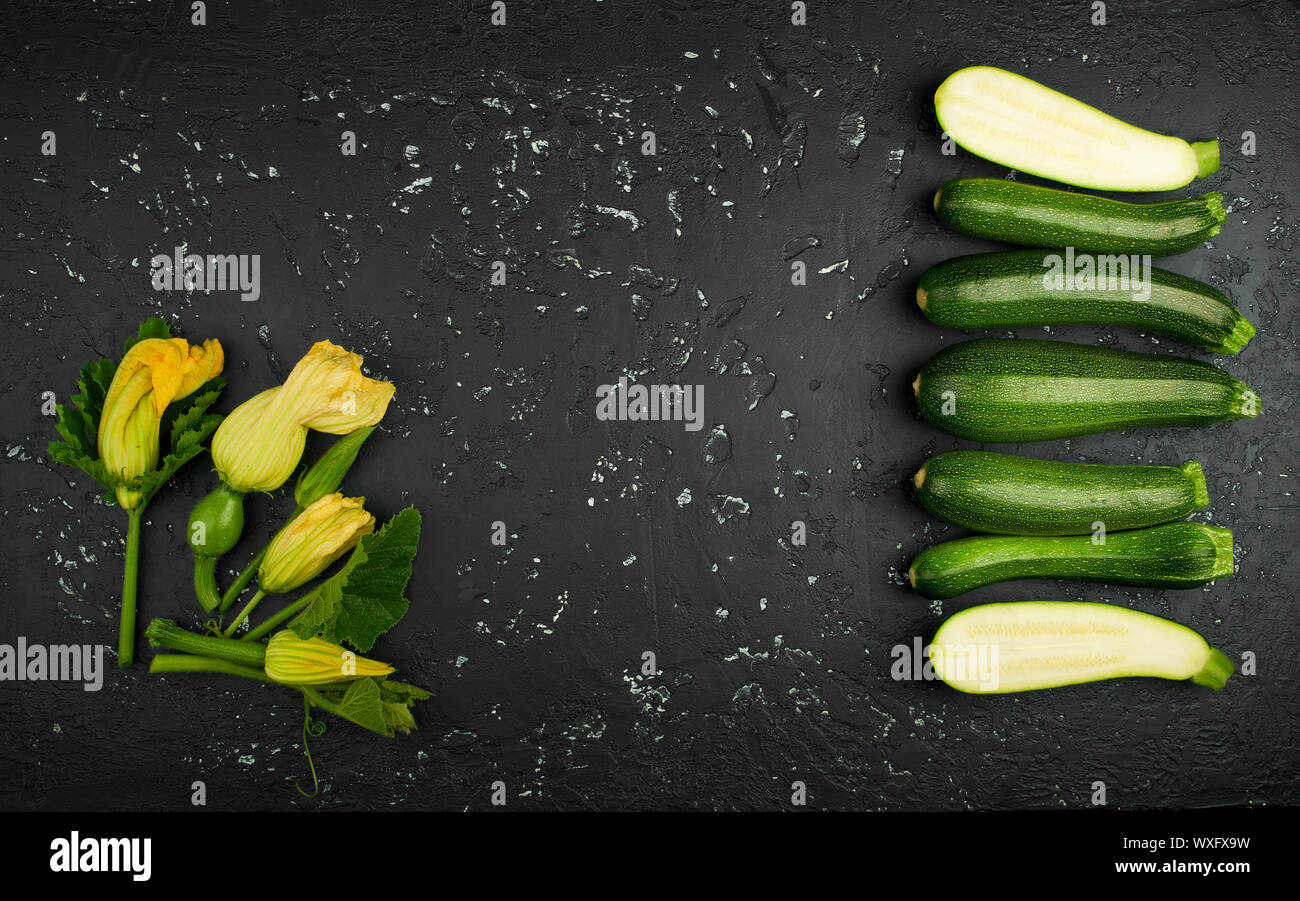 Fresco verde di zucchina al buio su un tavolo. La vista dall'alto. Copia dello spazio. Foto Stock