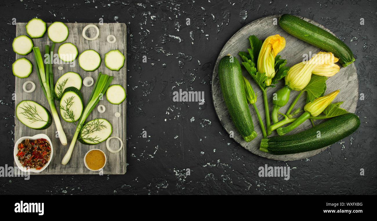 Fresco verde di zucchina al buio su un tavolo. La vista dall'alto. Copia dello spazio. Foto Stock