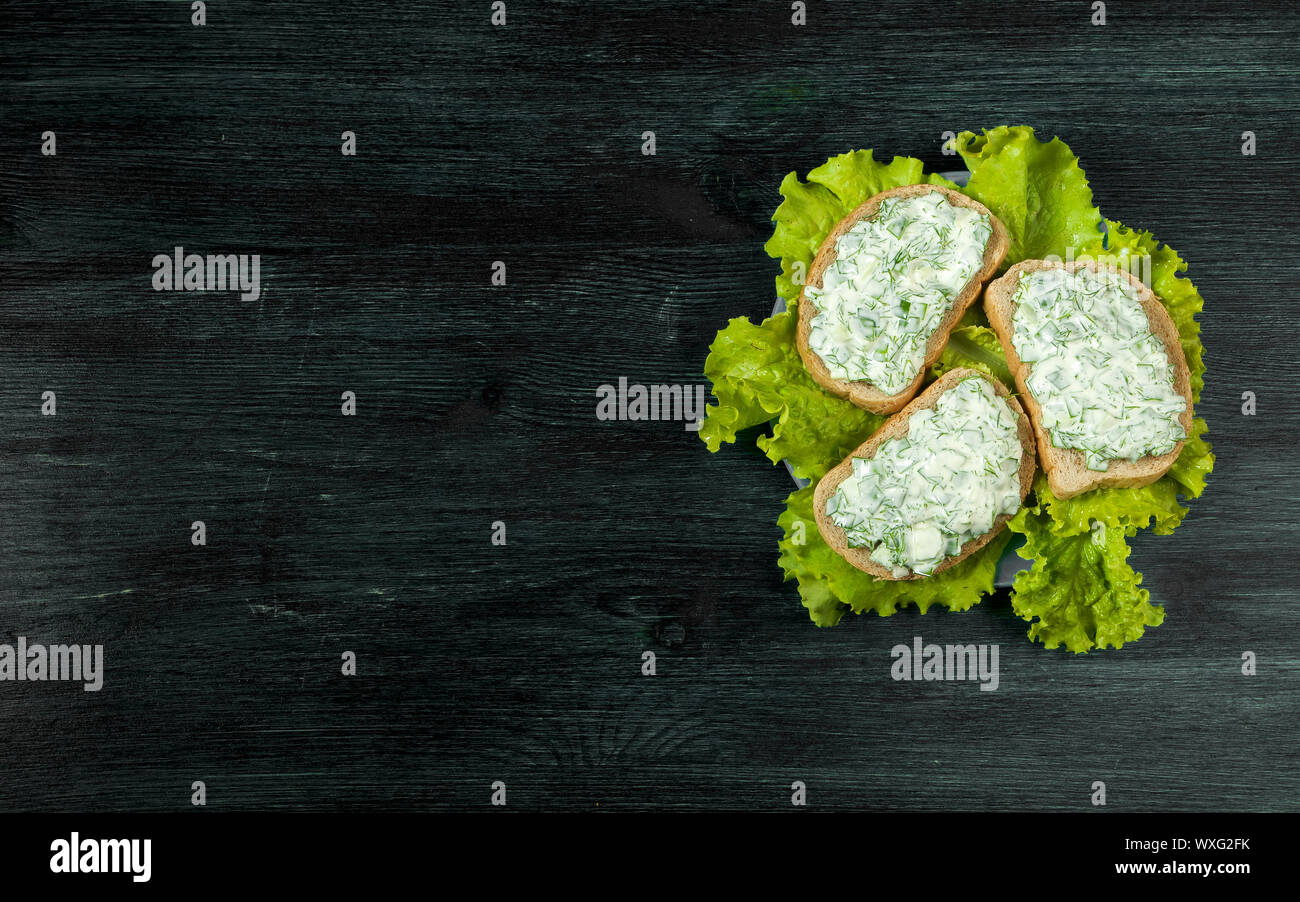 Panini con verdure. Sandwich freschi con verdure su un bordo scuro su uno sfondo a trama. Vista da sopra. Copia spa Foto Stock