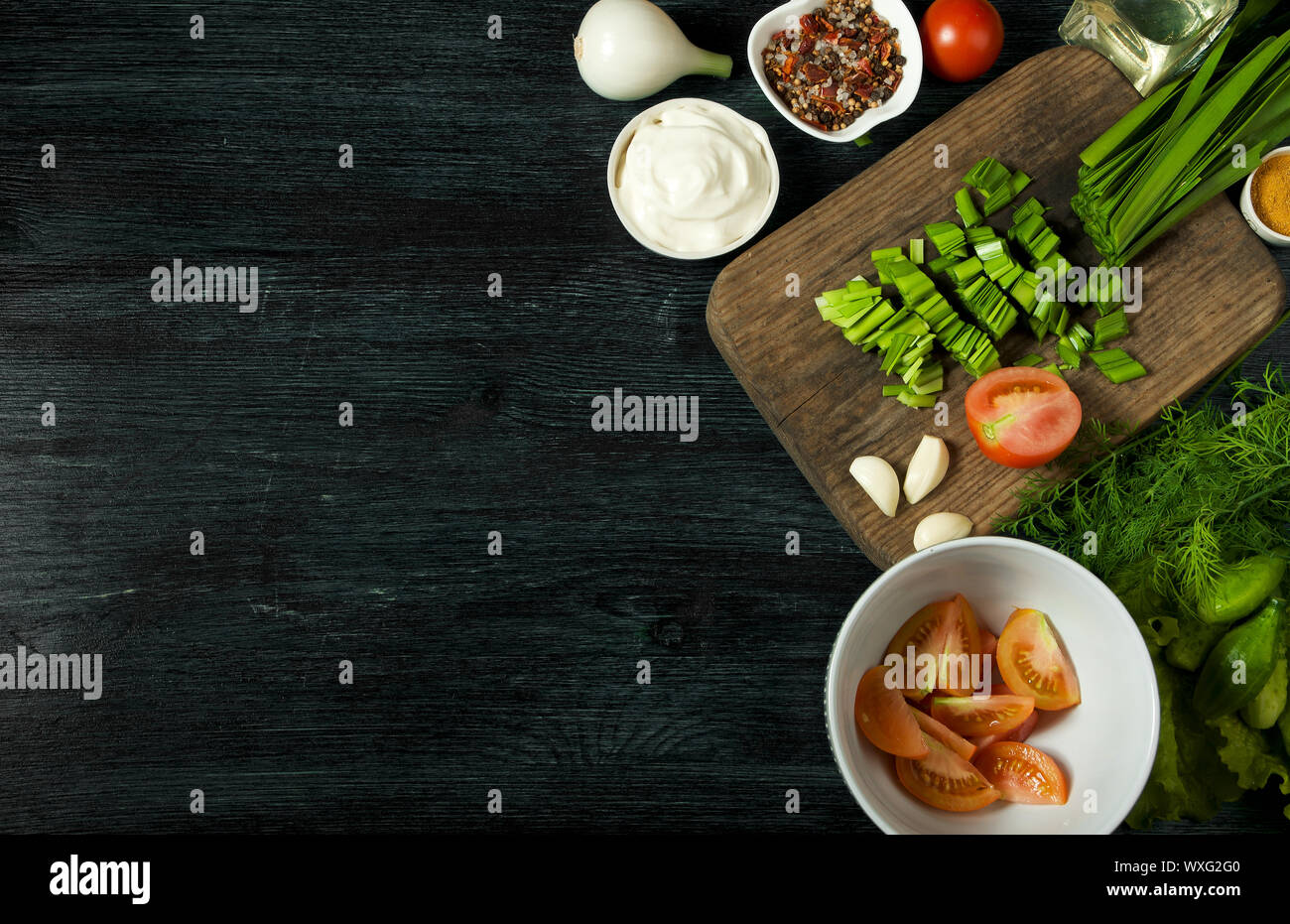 Verdure sullo sfondo. Ortaggi freschi su un bordo scuro su uno sfondo a trama. Vista da sopra. Copia dello spazio. Foto Stock