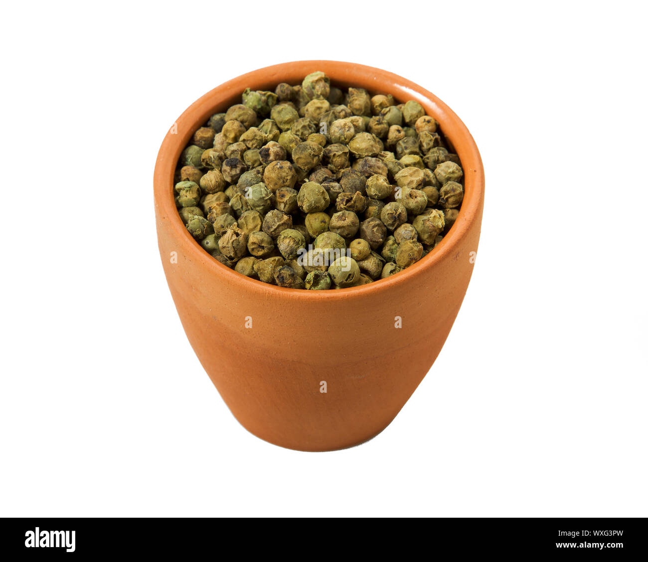 Il pepe verde in una ciotola di isolare. Vista da sopra. Il condimento con piselli di peperone verde isolato su uno sfondo bianco. Close-up Foto Stock
