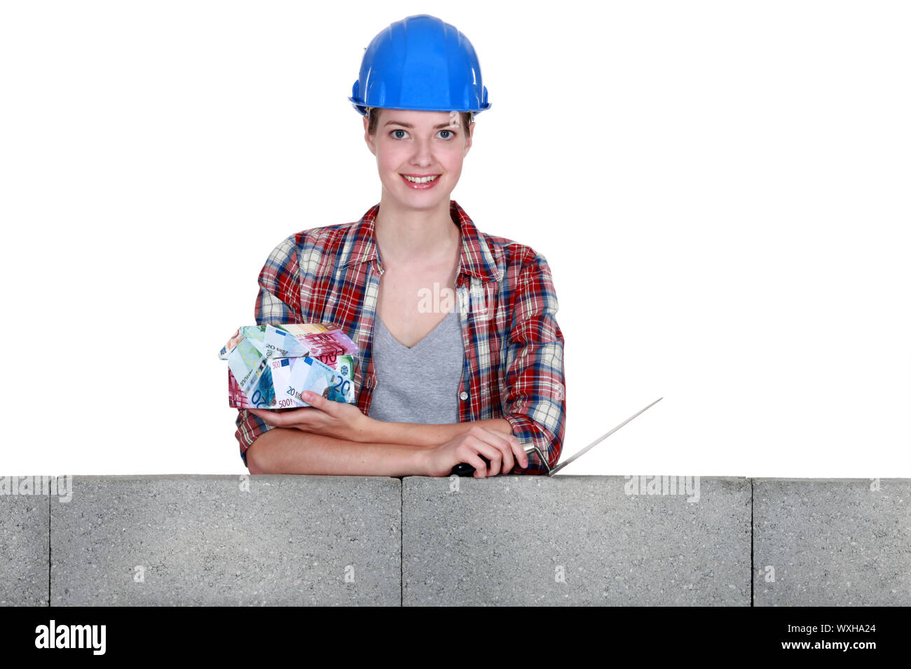 Donna con una casa fatta di denaro Foto Stock